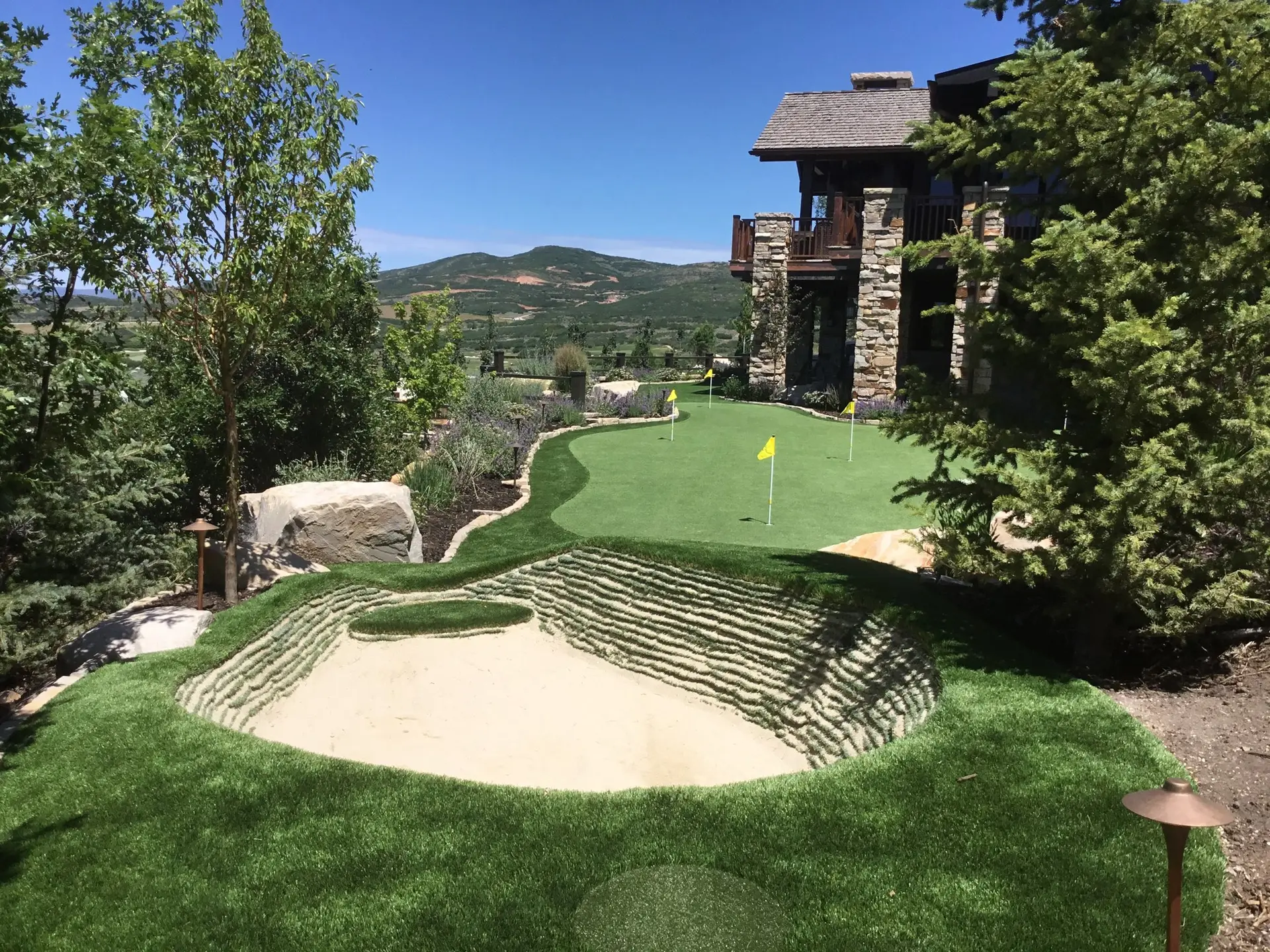 Signature mountain-estate putting green with artificial turf and panoramic views designed by Celebrity Greens®